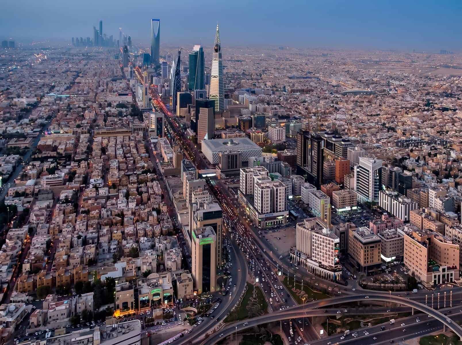 Aerial view of a modern city skyline with skyscrapers and busy roads.